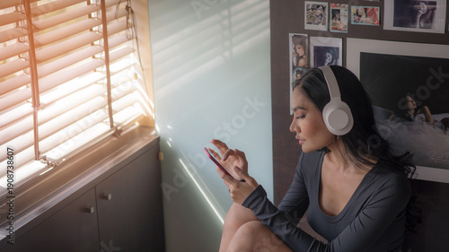 Canvas Print A teenage girl is using her smartphone to stream music to alleviate depression, heartbreak, and hopelessness