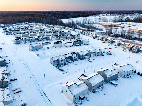 Drone image of suburban neighborhood development covered in snow from winter snow storm