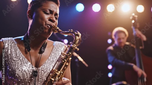 Female jazz musician plays saxophone on stage with band, live performance