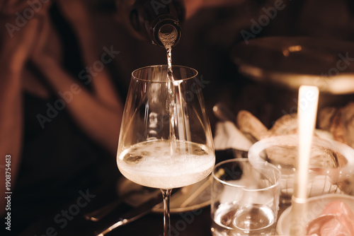 Group of guests celebrate and raise glasses, toasting and cheering with alcohol glasses with wine and champagne in the restaurant on corporate christmas birthday party event or wedding celebration