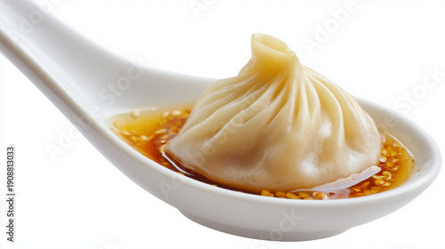 白い陶器の蓮華に盛り付けられた肉汁溢れるジューシーな小籠包と特製ダレのシズル感