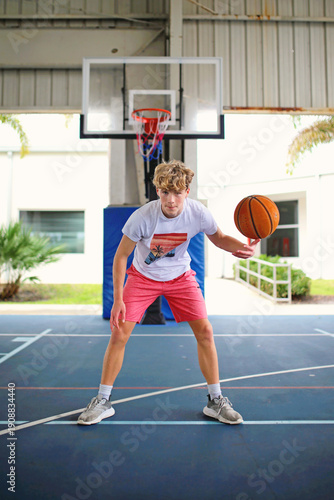 Teen Boy Playing Basketball Outside on Outdoor Court