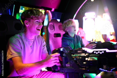 Kids Playing Shooting Video Game in Neon Light Arcade