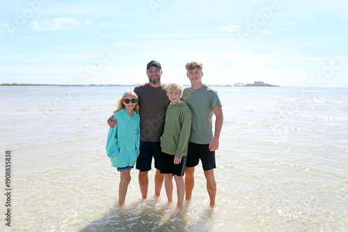 Happy Father and His Children Smiling on Beach on Ocean while on Family Vacation