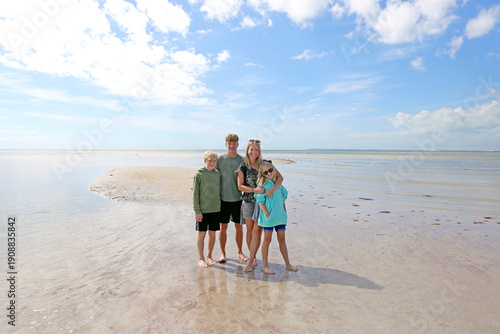 Happy Mother and Her Children On A Beautiful Beach on the Ocean