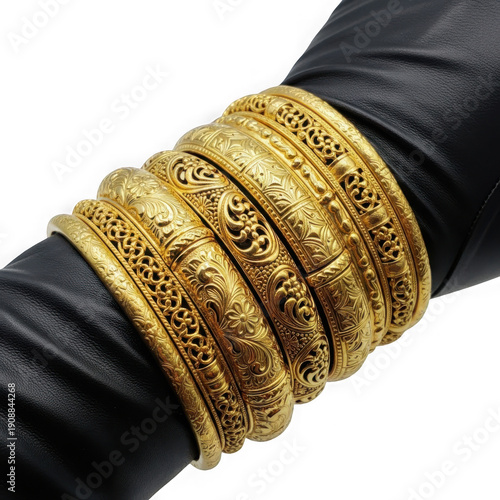 Stacked gold bracelets displayed on a human wrist with dark fabric background. isolated on transparent background