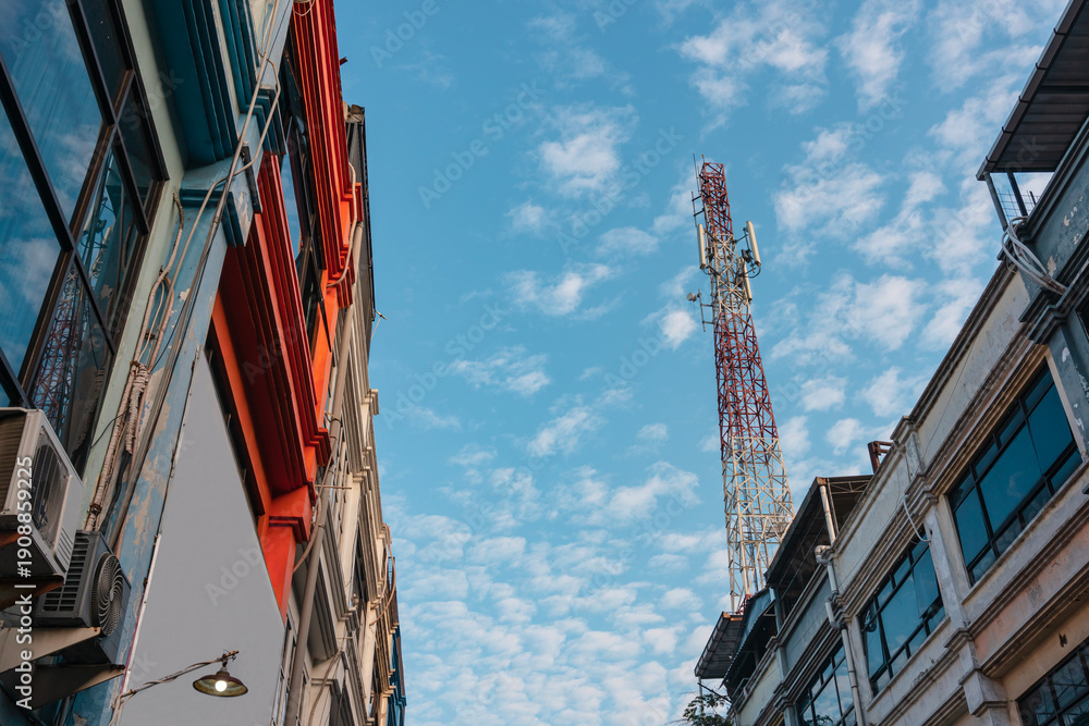 Fototapeta premium Cell phone tower on top of shop house building with clear sky in Surabaya, East Java, Indonesian.