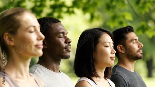 Diverse people meditating together in peaceful park with closed eyes