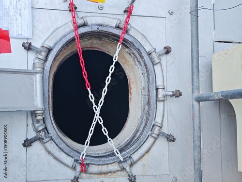 Bild auf Leinwand Confined space tank opening secured with red and white safety chains, indicating