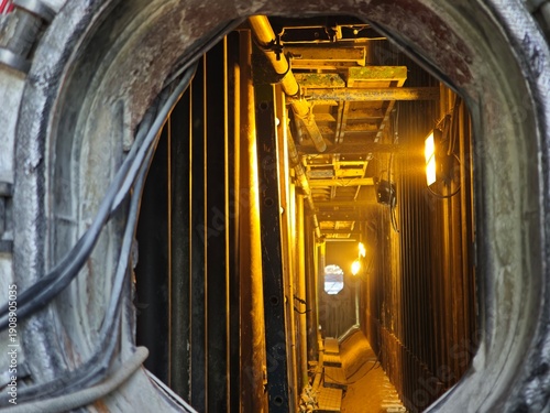 Foto View inside a confined space industrial chamber with lighting and piping, highlighting restricted access area, safety procedures, inspection work, and hazardous environment in heavy industry