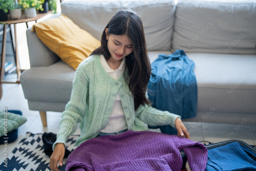 Obraz premium Happy asian Woman packing suitcase for travel planning preparing vacation &nbsp;in winter