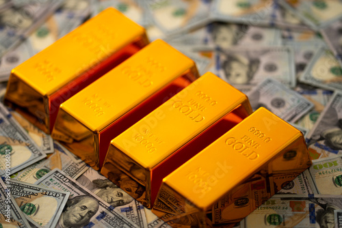 Gold bars and money. Golden bars stacked with US dollars in background. Gold bars for secure capital growth. Dollars money and gold concept. Financial success and saving Gold.
