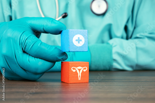 A doctor's hand holding wooden cubes and a uterus icon. Concept of uterine structural abnormalities, myomatosis detection, and clinical approach to fibroids in reproductive health.