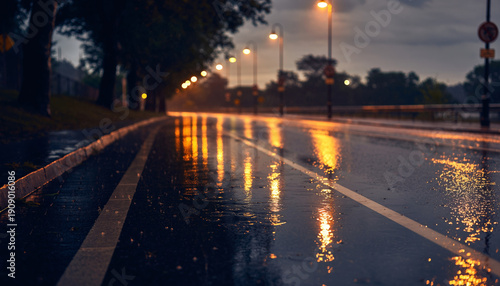 Empty wet road at dusk with streetlights and reflections on the surface.