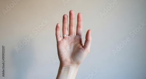 Human hand raised against neutral background close up photography