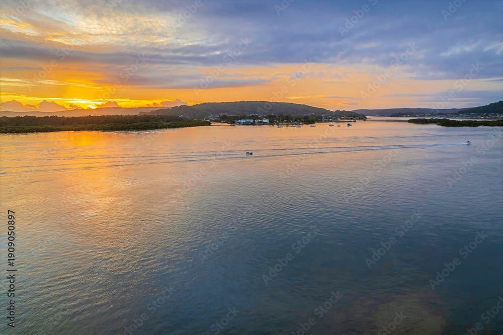 Fototapeta premium Sunrise waterscape with a mix of low, medium and high clouds
