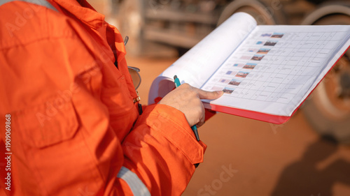 Quadro su tela Close-up at operation supervisor hand in action of checking on the document and certification during perform safety audit at construction working site