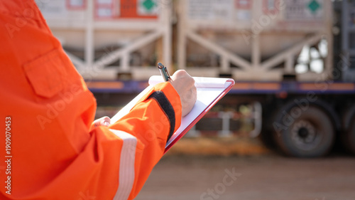 Canvastavla A safety officer is checking on safety checklist to verify the risk of chemical transportation with Liquid nitrogen tank on background