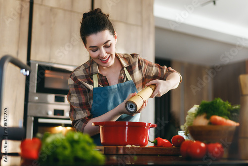 Cuadro en lienzo Smiling Woman Cooking in Home Kitchen with Fresh Vegetables