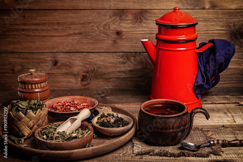 cup of herbal tea and ingredients on wooden table