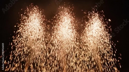 Four streams of sparks ascending in darkness, creating a spectacle of light and color