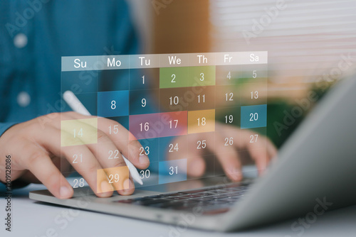 Digital calendar planning concept with virtual schedule interface over laptop keyboard. Online appointment management, business deadline reminder, time management and productivity technology.