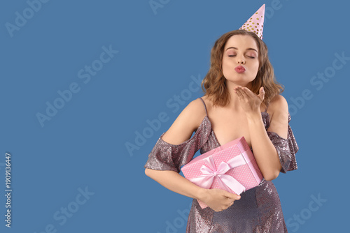 Young woman in party hat wi...