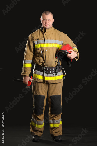 Male firefighter with axe o...