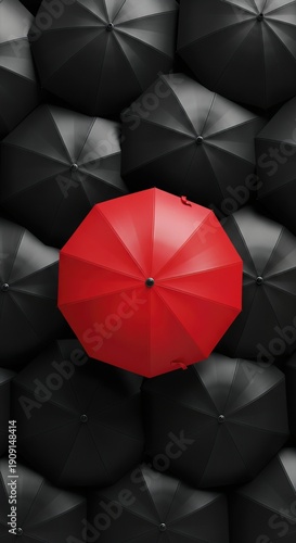 A Red Umbrella Standing Out from the Crowd of Black Umbrellas in a Unique Perspective