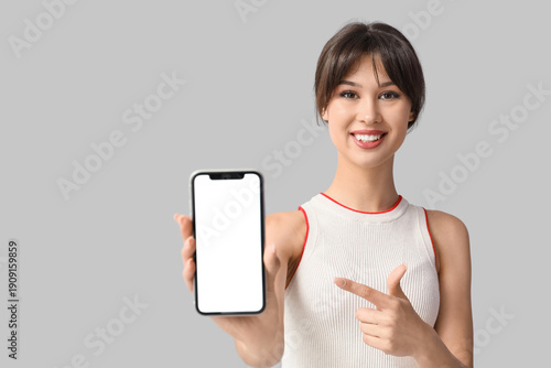 Smiling young woman pointin...
