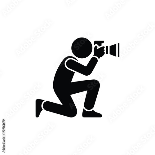 A black silhouette of a photographer kneeling with a camera