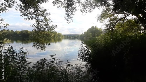Spring lake landscape shows trees reflecting perfectly in calm water near Regensburg Germany
