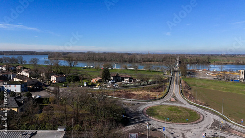 Fotografia Aerial view of San Nazzaro and the Po River bridge on a clear winter day