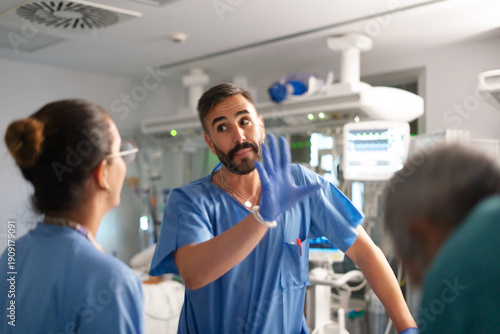 Billede på lærred Surgeon making hand gesture explaining during medical procedure