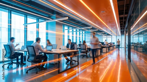 Diverse professionals work at desks in a vibrant open-plan office, featuring orange floors, modern linear lighting, with motion blur.