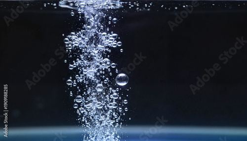A dense wall of small bubbles against the black background of an aquarium