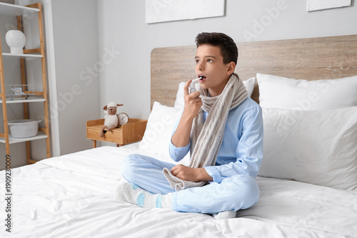 Sick little boy using spray...