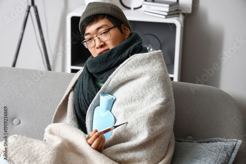 Ill Asian man with hot wate...