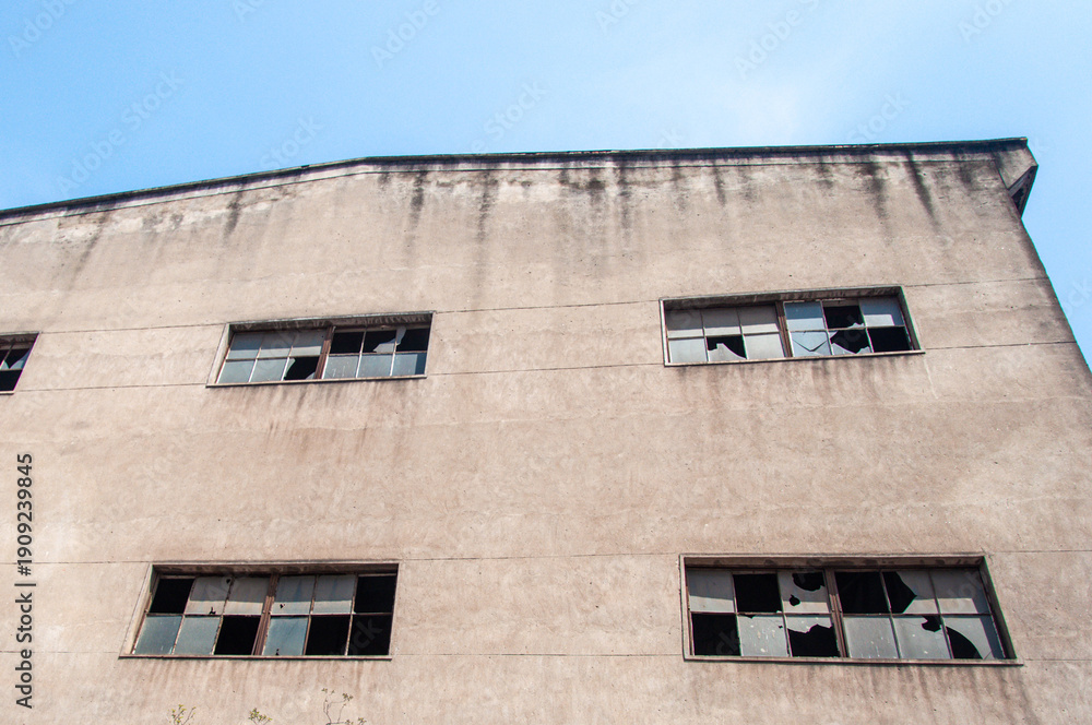 Fototapeta premium Low Angle View of Concrete Facade with Broken Windows