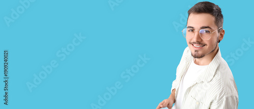 Young man in eyeglasses on blue background, closeup