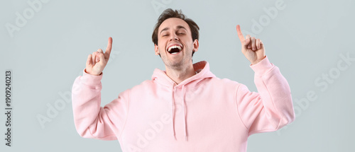 Young man pointing at somet...