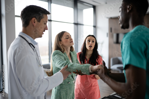 Medical professionals helping patient feeling faint in clinic