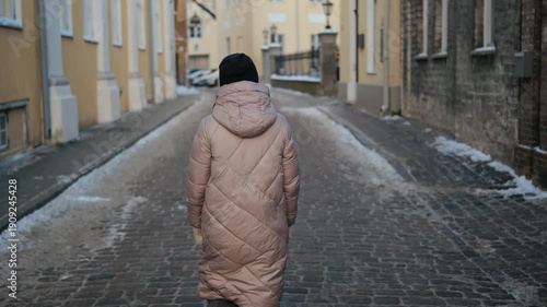 Walking along a quiet cobblestone street in winter in a historic town