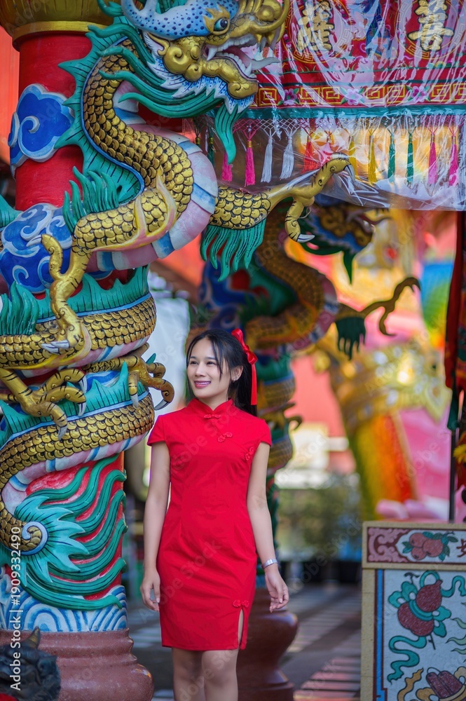 Fototapeta premium Young Woman in Traditional Red Dress Near Colorful Dragon Decorations