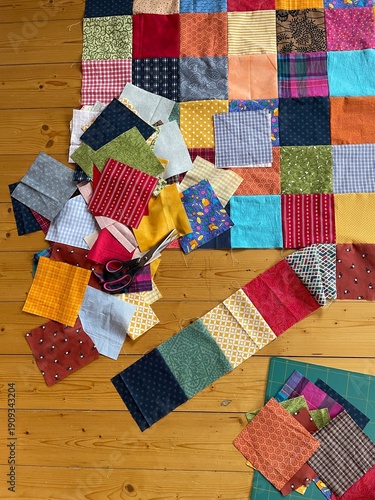 Many square colorful cotton patches for a quilt and patchwork blanket are just being selected put together