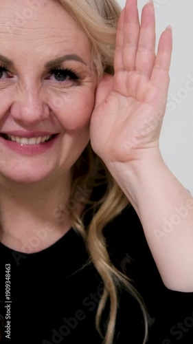 An adult woman playing hide-and-seek, covering her eyes with her palms, looking out, smiling, laughing, looking at the camera, a European woman