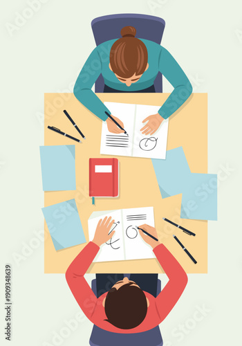 Collaborative vector illustration of two designers working together on a project at a desk with papers and pens, viewed from above