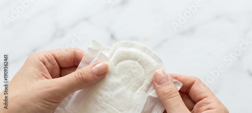 Womans hands opening sanitary pad for feminine hygiene, period care product, discreet packaging, comfort and protection concept