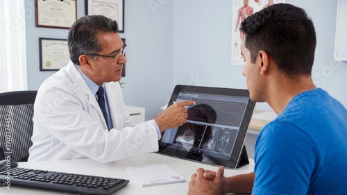 Doctor and patient clinic consultation as medical doctor explains scan results with radiology imaging charts, touchscreen tablet review and attentive