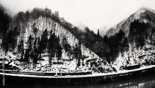 Valokuva Serene snow‑covered winter scenes of the Hida Mountain foothills of the Japanese Alps along the Miyagawa River in Gifu Prefecture, Japan in a black‑and‑white retro style
